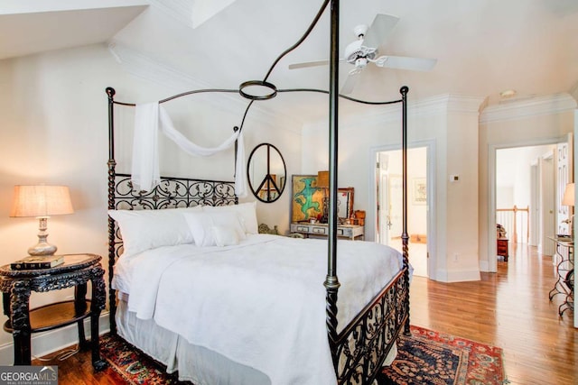 bedroom with wood finished floors, baseboards, and ornamental molding