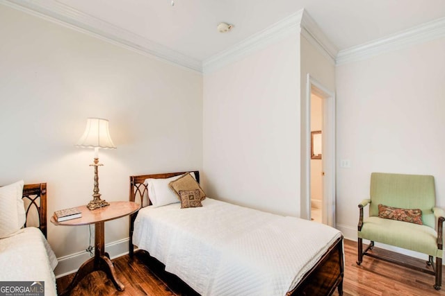 bedroom with crown molding, wood finished floors, and baseboards