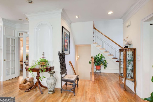 entryway featuring light wood-style floors, recessed lighting, crown molding, and stairway