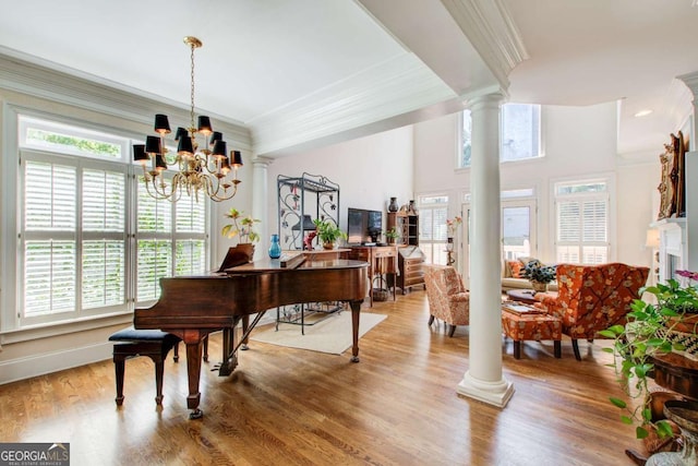 living area with ornamental molding, ornate columns, and plenty of natural light