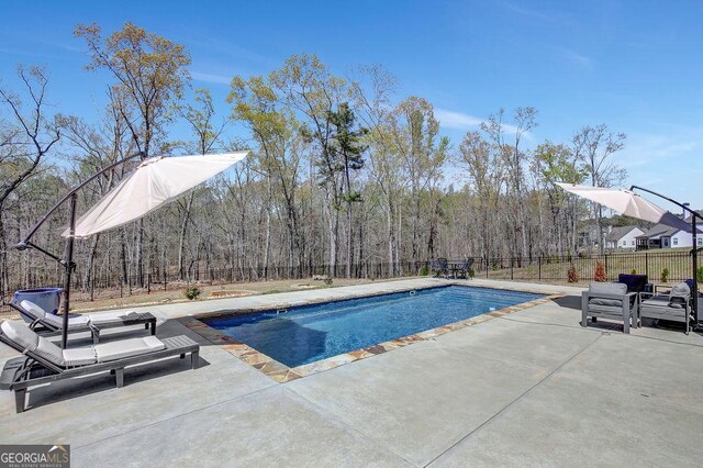 view of swimming pool with a fenced backyard, a fenced in pool, and a patio