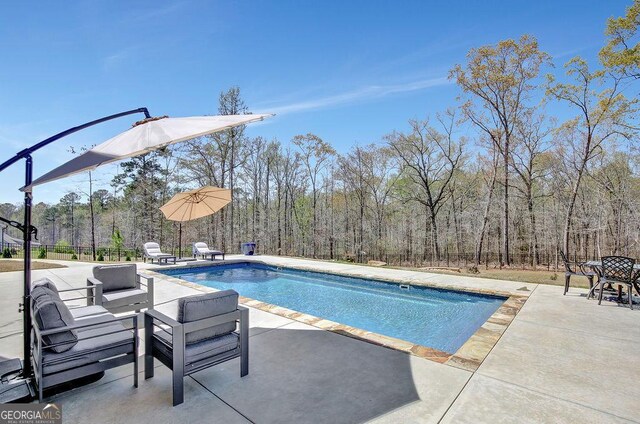 view of pool featuring a patio area, fence, and a fenced in pool