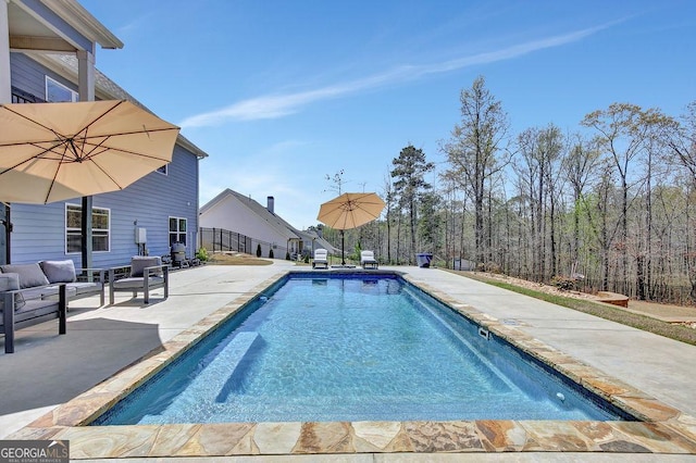 view of swimming pool featuring a fenced in pool and a patio area
