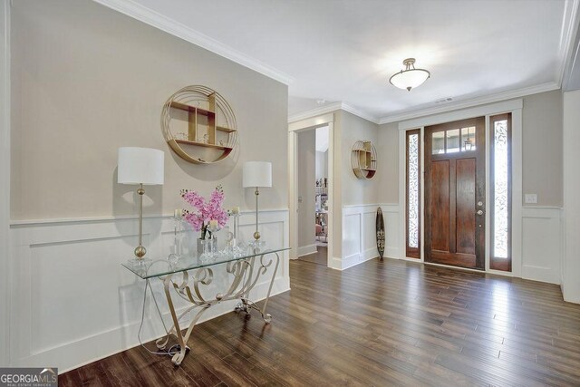 entryway featuring a decorative wall, wainscoting, crown molding, and wood finished floors