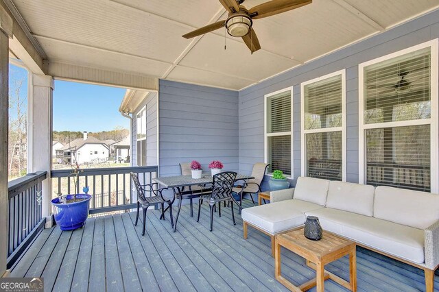 wooden deck with an outdoor living space and ceiling fan