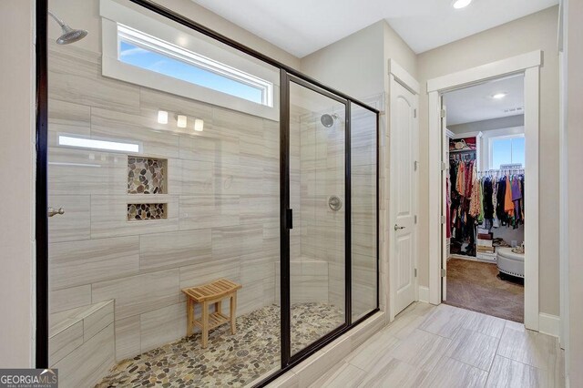 full bath with a shower stall, recessed lighting, a spacious closet, and baseboards