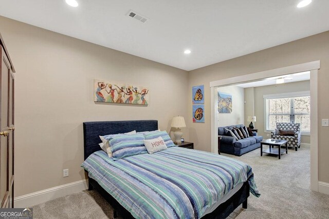 bedroom with recessed lighting, visible vents, light colored carpet, and baseboards