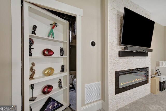 room details with a glass covered fireplace and visible vents