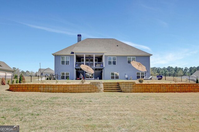 back of property with fence, a yard, and a chimney