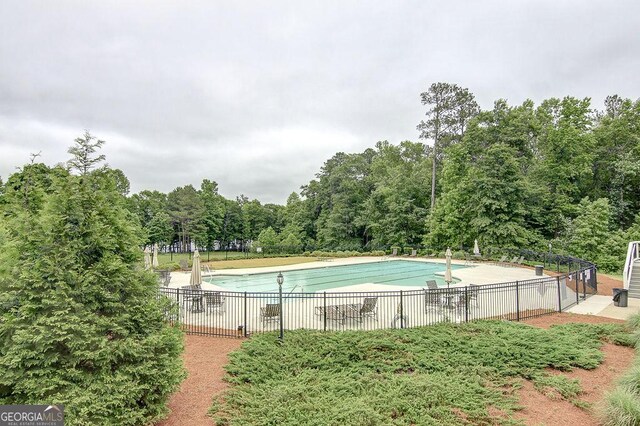 pool with a patio and fence