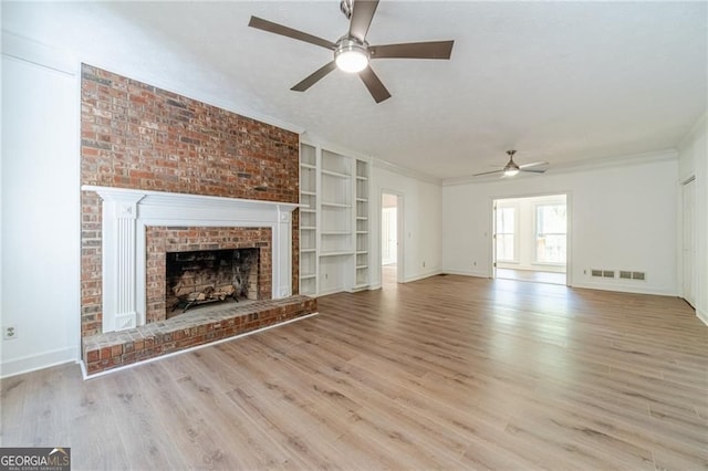 3775 Belle Glade Trl, Snellville, GA 30039 - unfurnished living room featuring ceiling fan, wood finished floors, a brick fireplace, crown molding, and built in features
