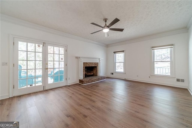 3775 Belle Glade Trl, Snellville, GA 30039 - unfurnished living room with wood finished floors, a ceiling fan, a textured ceiling, crown molding, and a fireplace