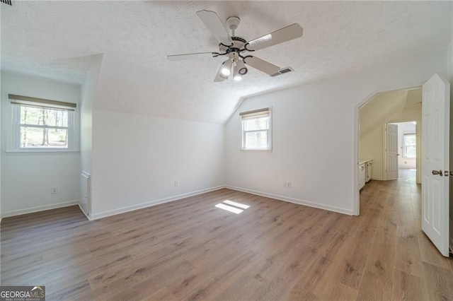 3775 Belle Glade Trl, Snellville, GA 30039 - additional living space featuring vaulted ceiling, light wood-type flooring, a textured ceiling, and a ceiling fan