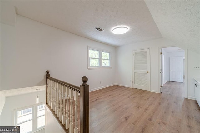 3775 Belle Glade Trl, Snellville, GA 30039 - corridor with a textured ceiling, an upstairs landing, and light wood-style floors