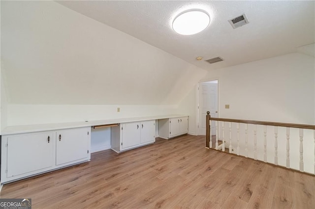 3775 Belle Glade Trl, Snellville, GA 30039 - additional living space with lofted ceiling, built in desk, light wood finished floors, and a textured ceiling