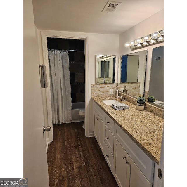 173 Amherst Pl NW, Atlanta, GA 30327 - full bathroom with visible vents, wood finished floors, vanity, toilet, and shower / bath combo with shower curtain