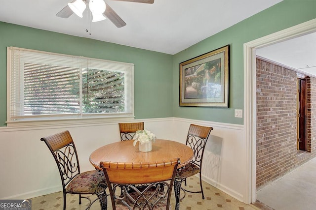 dining area featuring baseboards, a ceiling fan, and a wealth of natural light