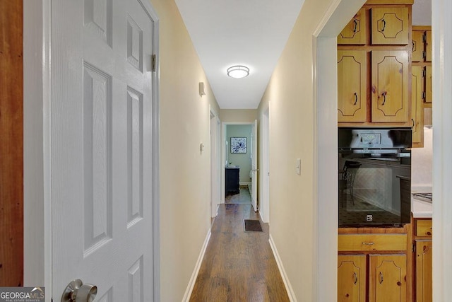hall featuring dark wood-style floors, baseboards, and visible vents