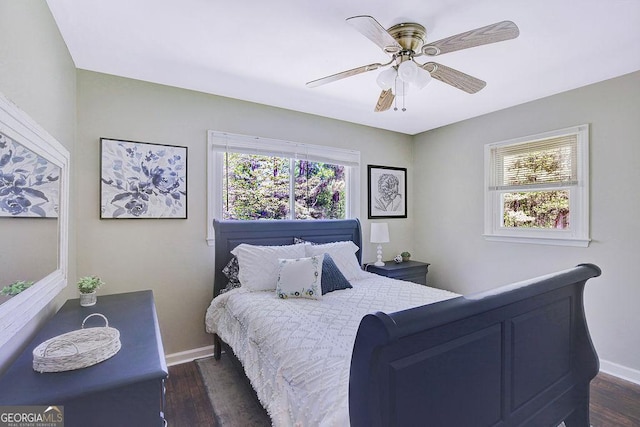 bedroom featuring baseboards, ceiling fan, and dark wood-style floors
