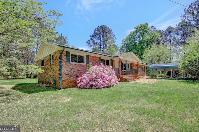 single story home featuring brick siding, a front yard, covered porch, and a carport
