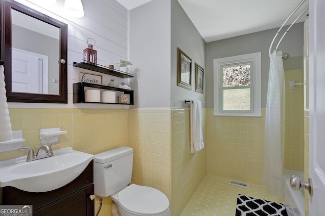 full bath with a shower with shower curtain, vanity, toilet, visible vents, and tile walls