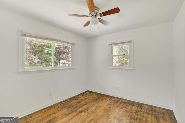 unfurnished room featuring ceiling fan, baseboards, visible vents, and hardwood / wood-style flooring