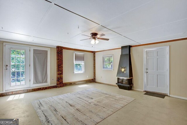 unfurnished living room featuring baseboards and a ceiling fan