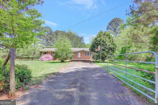 view of street with driveway, a gated entry, and a gate