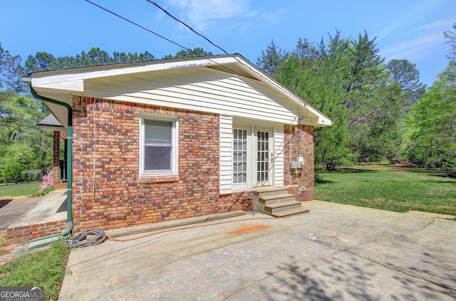 view of property exterior with brick siding and a lawn