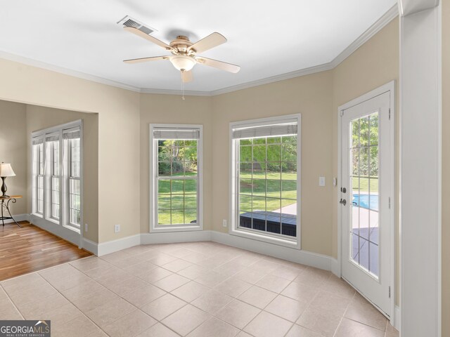 unfurnished room featuring ornamental molding, ceiling fan, light tile patterned floors, and a healthy amount of sunlight