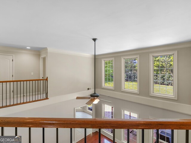 interior space with crown molding, ceiling fan, and visible vents