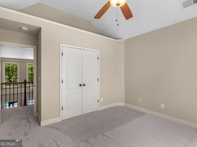 unfurnished bedroom with visible vents, baseboards, vaulted ceiling, and carpet floors