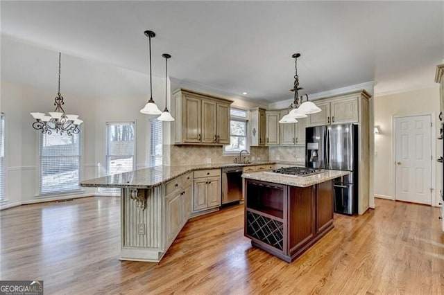kitchen with light wood-style floors, stainless steel appliances, a notable chandelier, and a peninsula