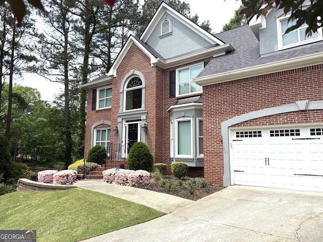 view of front facade with concrete driveway, roof with shingles, a front lawn, and brick siding