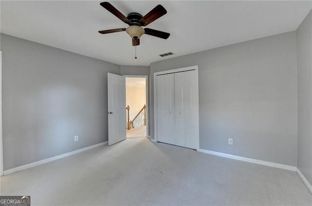 unfurnished bedroom featuring baseboards, visible vents, carpet floors, and a closet