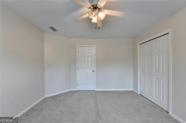 unfurnished bedroom with a closet, visible vents, carpet floors, and baseboards