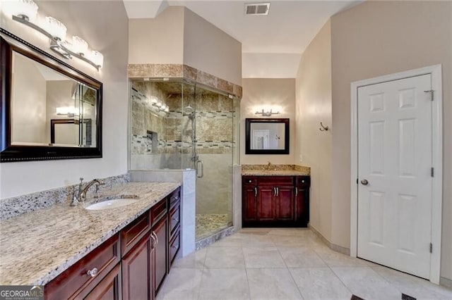 bathroom with tile patterned flooring, two vanities, a sink, visible vents, and a stall shower