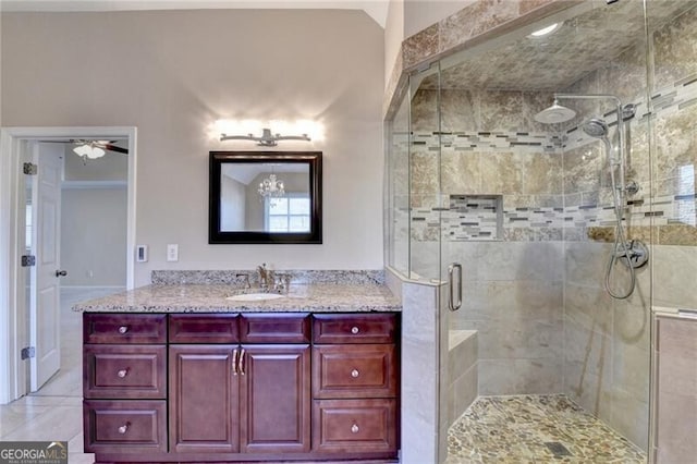 full bathroom featuring ceiling fan, a shower stall, and vanity