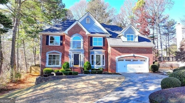 view of front facade with concrete driveway, an attached garage, and brick siding