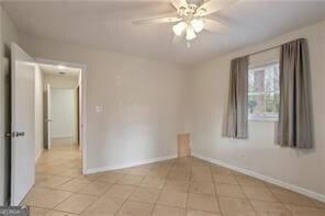 unfurnished room with light tile patterned floors, baseboards, and a ceiling fan
