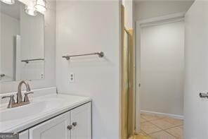 bathroom with vanity, baseboards, and tile patterned flooring