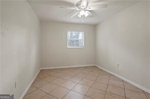 unfurnished room with light tile patterned floors, baseboards, and a ceiling fan