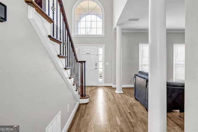 3139 Players Dr, Jonesboro, GA 30236 - entrance foyer with ornate columns, wood finished floors, baseboards, crown molding, and stairs