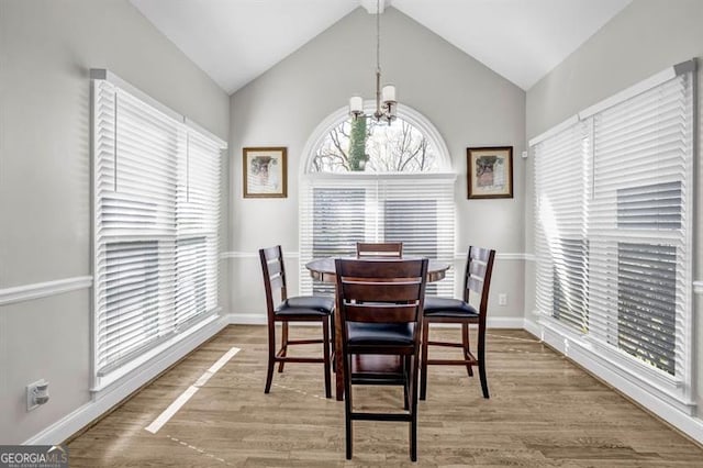 3139 Players Dr, Jonesboro, GA 30236 - dining room with a chandelier, baseboards, wood finished floors, and lofted ceiling