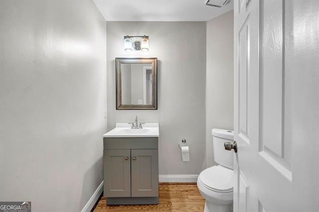3139 Players Dr, Jonesboro, GA 30236 - half bathroom featuring toilet, vanity, wood finished floors, and baseboards