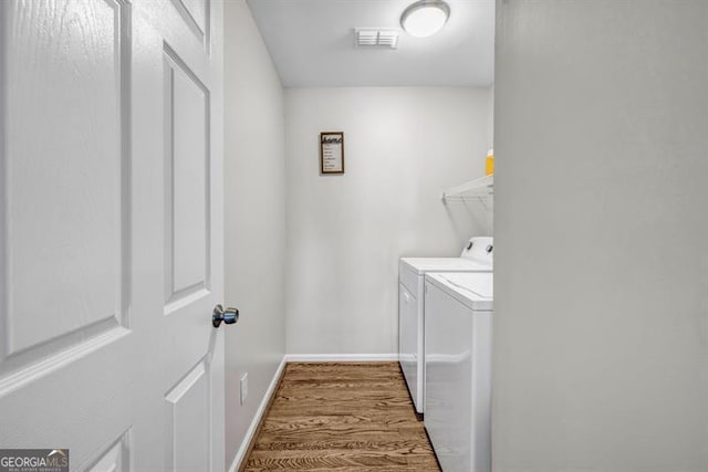 3139 Players Dr, Jonesboro, GA 30236 - laundry area with separate washer and dryer, wood finished floors, and baseboards