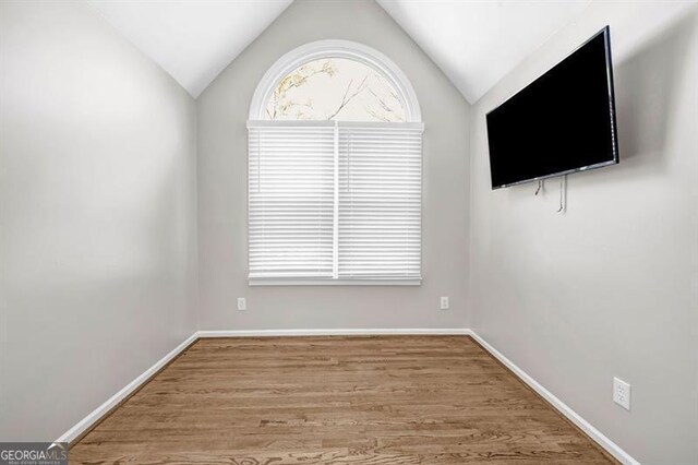 3139 Players Dr, Jonesboro, GA 30236 - empty room with vaulted ceiling, wood finished floors, and baseboards