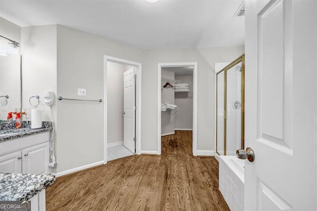 3139 Players Dr, Jonesboro, GA 30236 - full bath featuring vanity, a shower stall, a walk in closet, wood finished floors, and baseboards