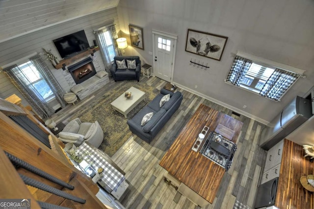 517 Monet Dr Unit 1144R, Ellijay, GA 30540 - living area featuring a towering ceiling, a warm lit fireplace, wood walls, and wood finished floors