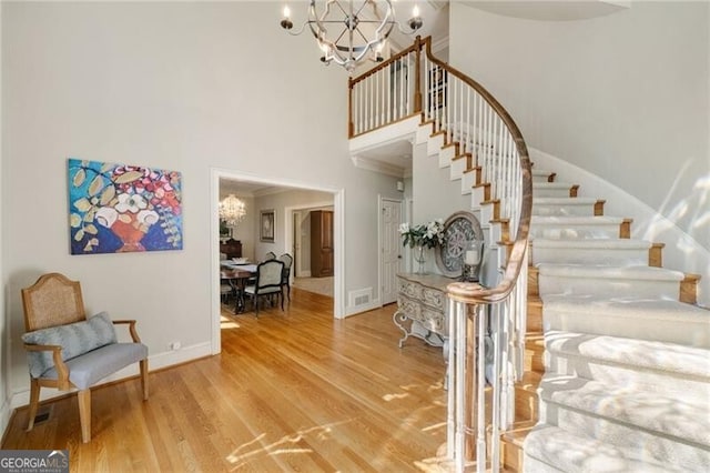 5520 Glen Errol Rd, Atlanta, GA 30327 - stairway with a chandelier, a high ceiling, wood finished floors, and crown molding